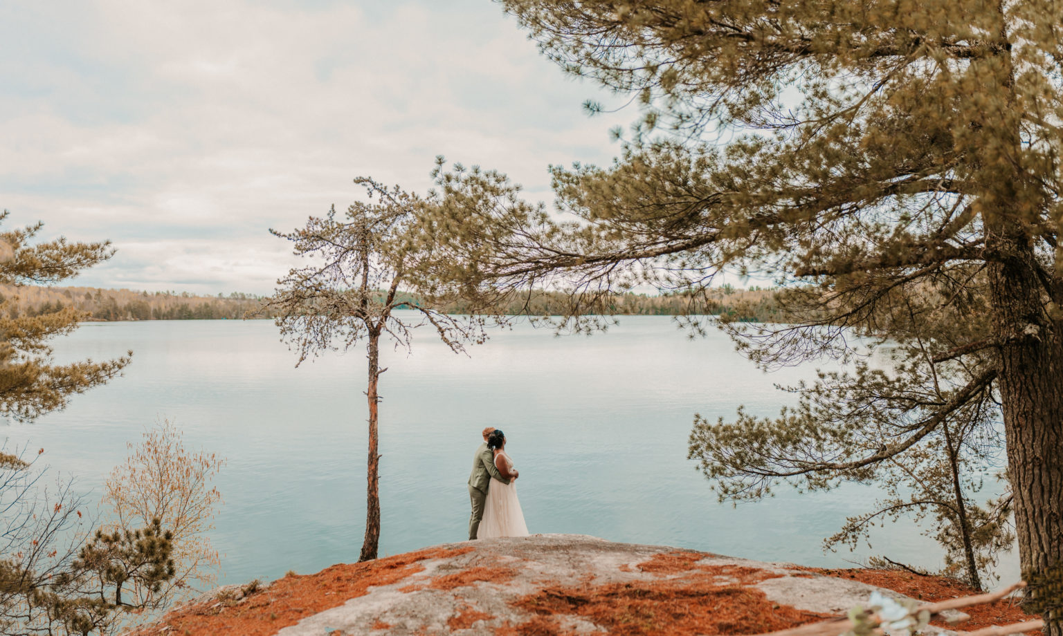 Couple holding each other and looking out onto the lake during their elopement.