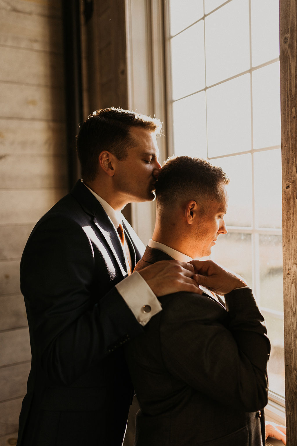LGBTQ+ couple sharing a moment in front of a window.