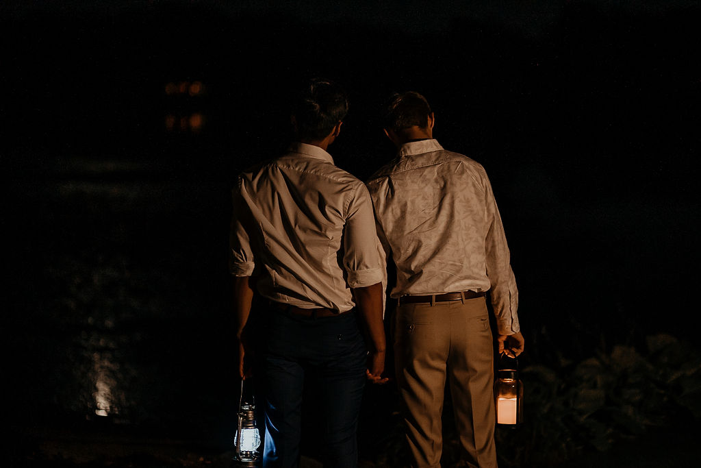 Couple holding lanterns in the dark during their elopement.