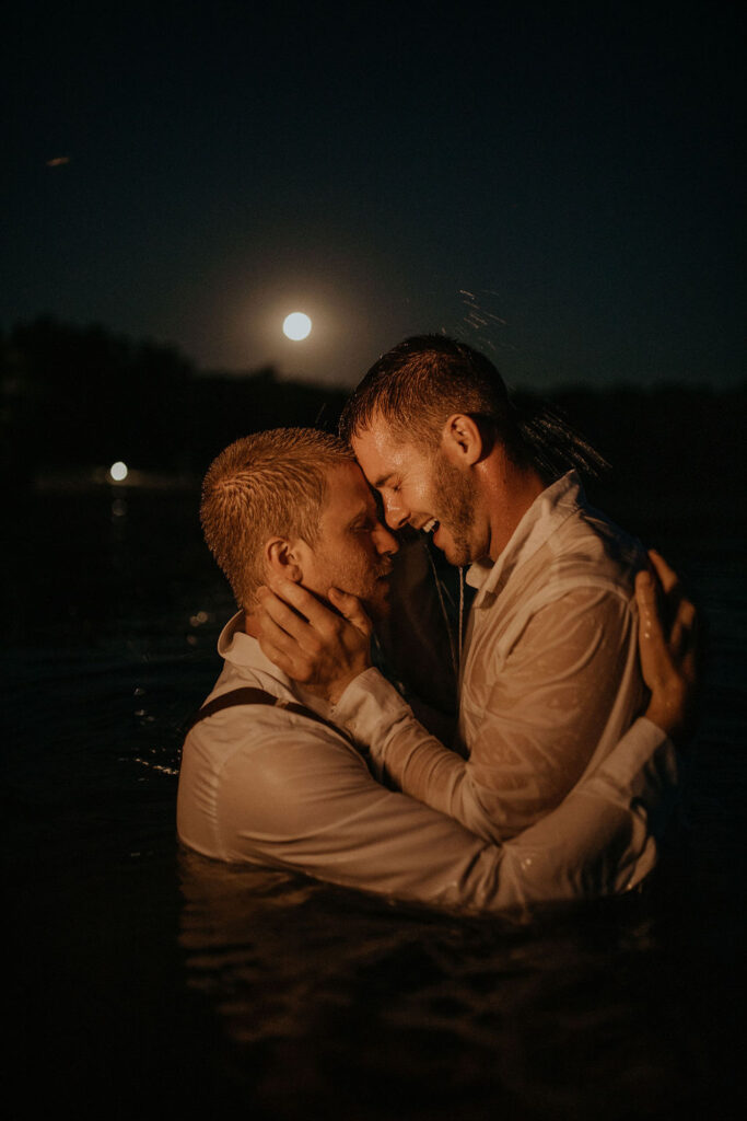 Couple poses in the water in the dark after elopement.