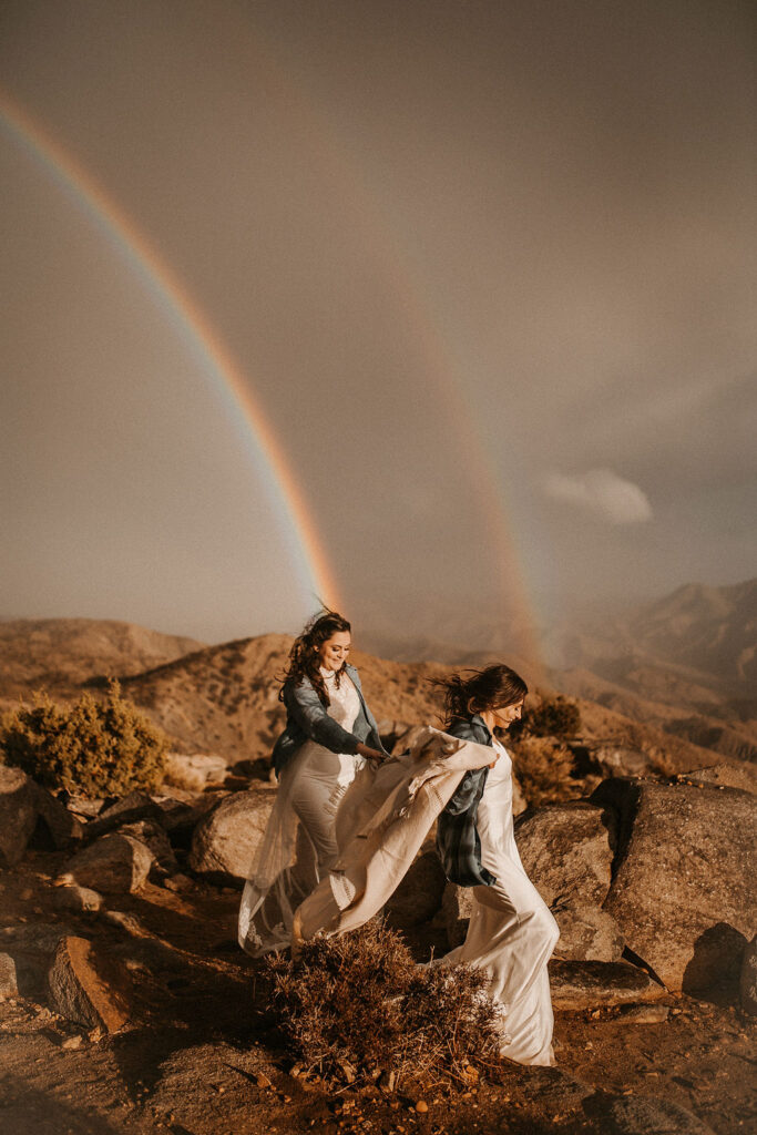 Eloping couple in front of a double rainbow.