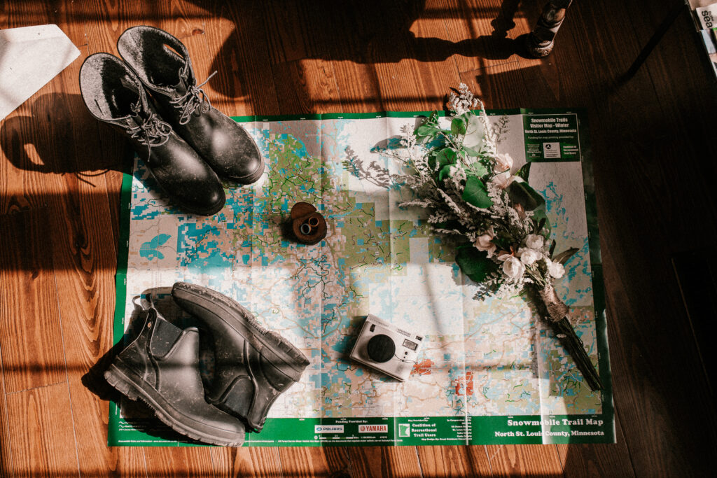 Map with boots, a camera, rings, and flowers.