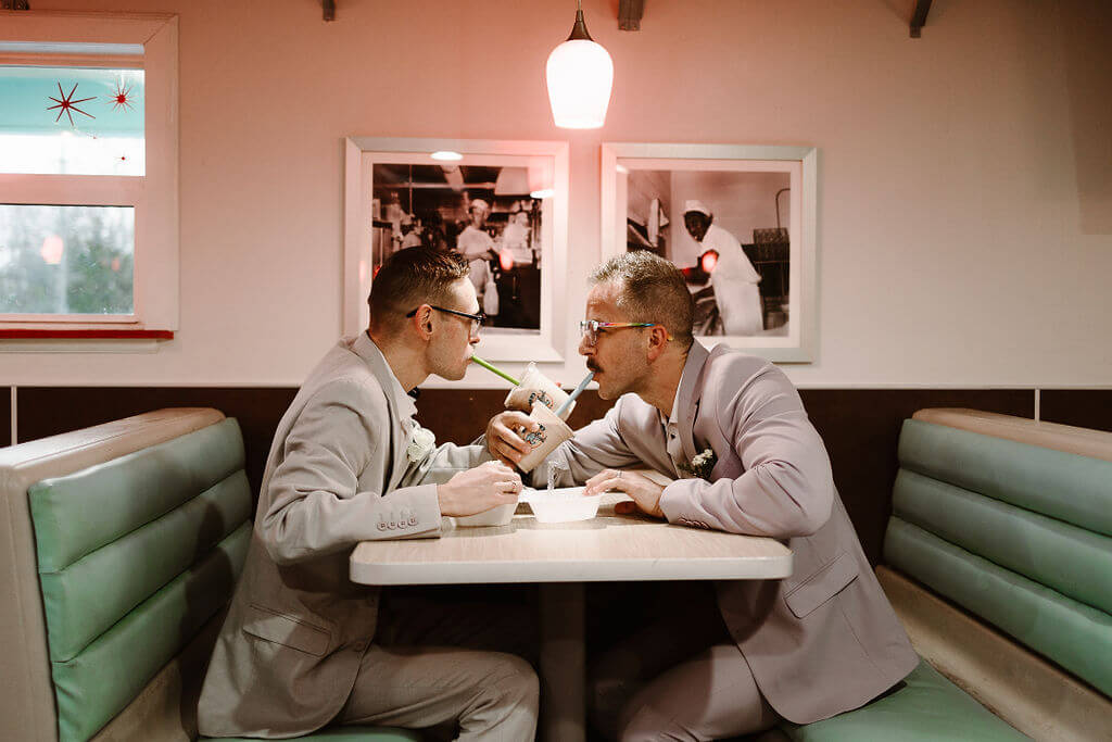 Couple having milkshakes at a diner.
