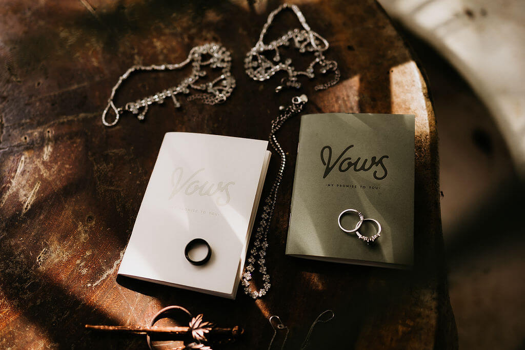 Vow books and rings at couple's elopement.